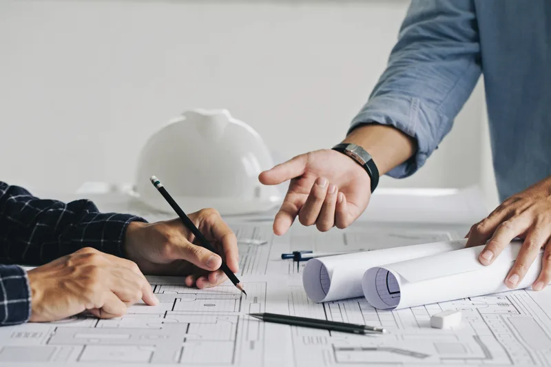 Technical drawing review with hands and drawings